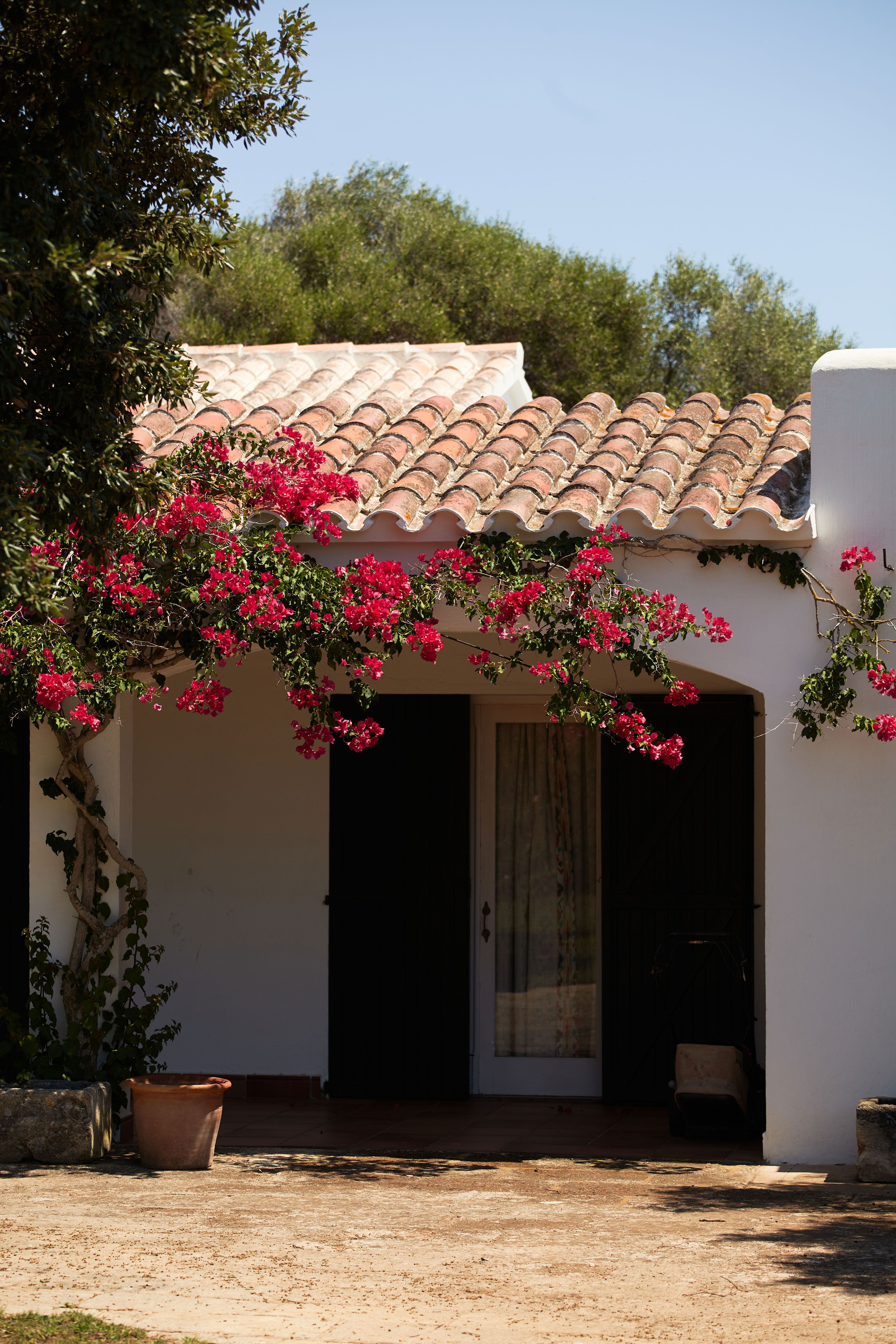 Patio interior de una casa menorquina en Mahón con luz natural y paredes claras.