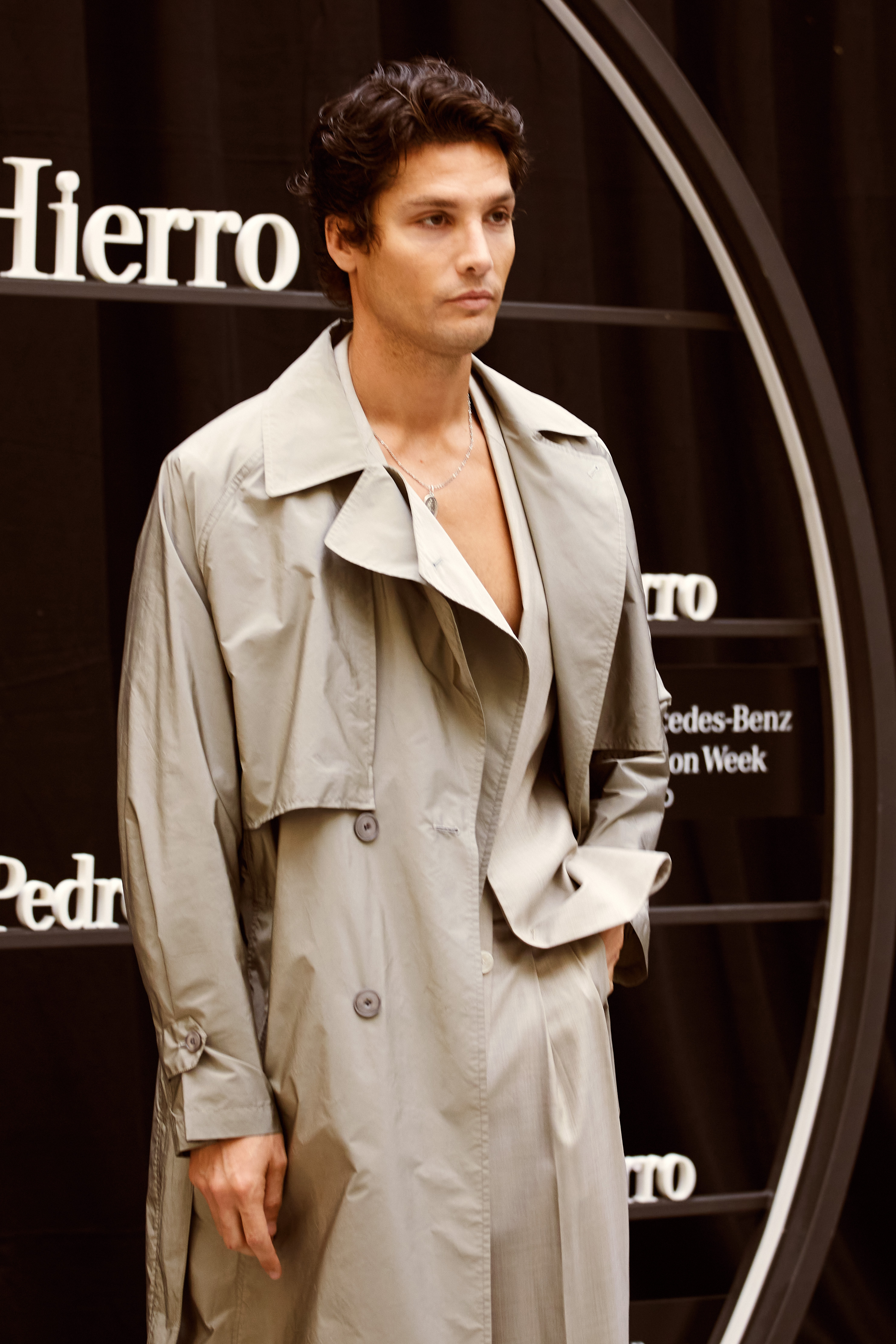 Modelo masculino posando frente al step and repeat de Pedro del Hierro en MBFWM 2025