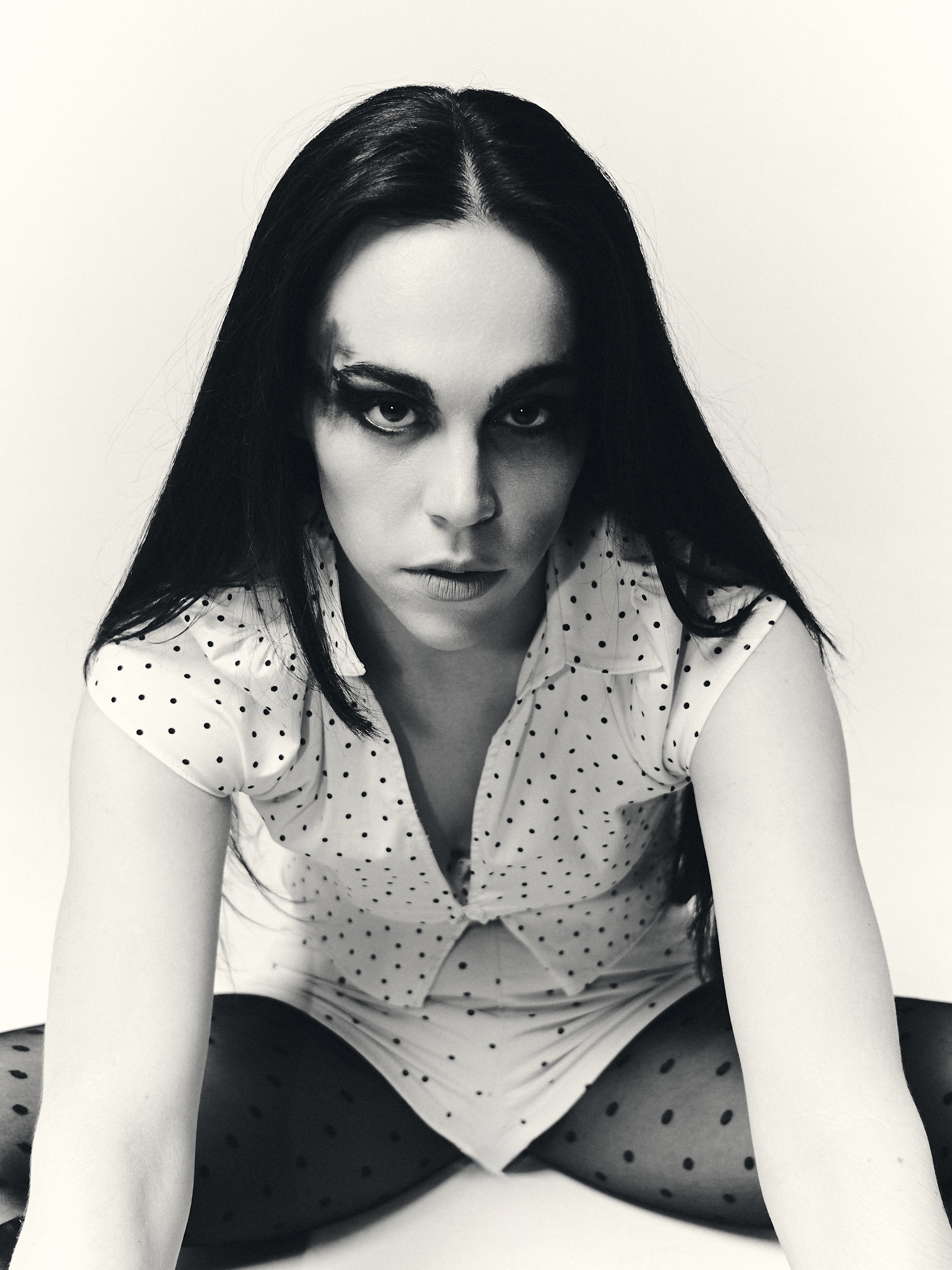 Mid-shot editorial portrait with minimalist composition and polka dot garments