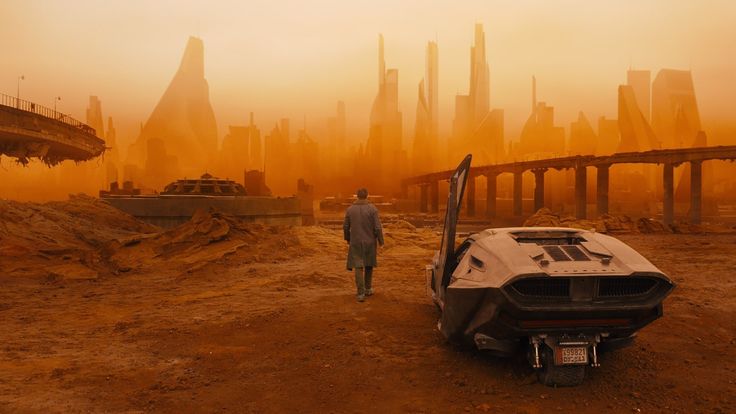 K en un entorno urbano oscuro y contaminado en una escena de Blade Runner 2049.