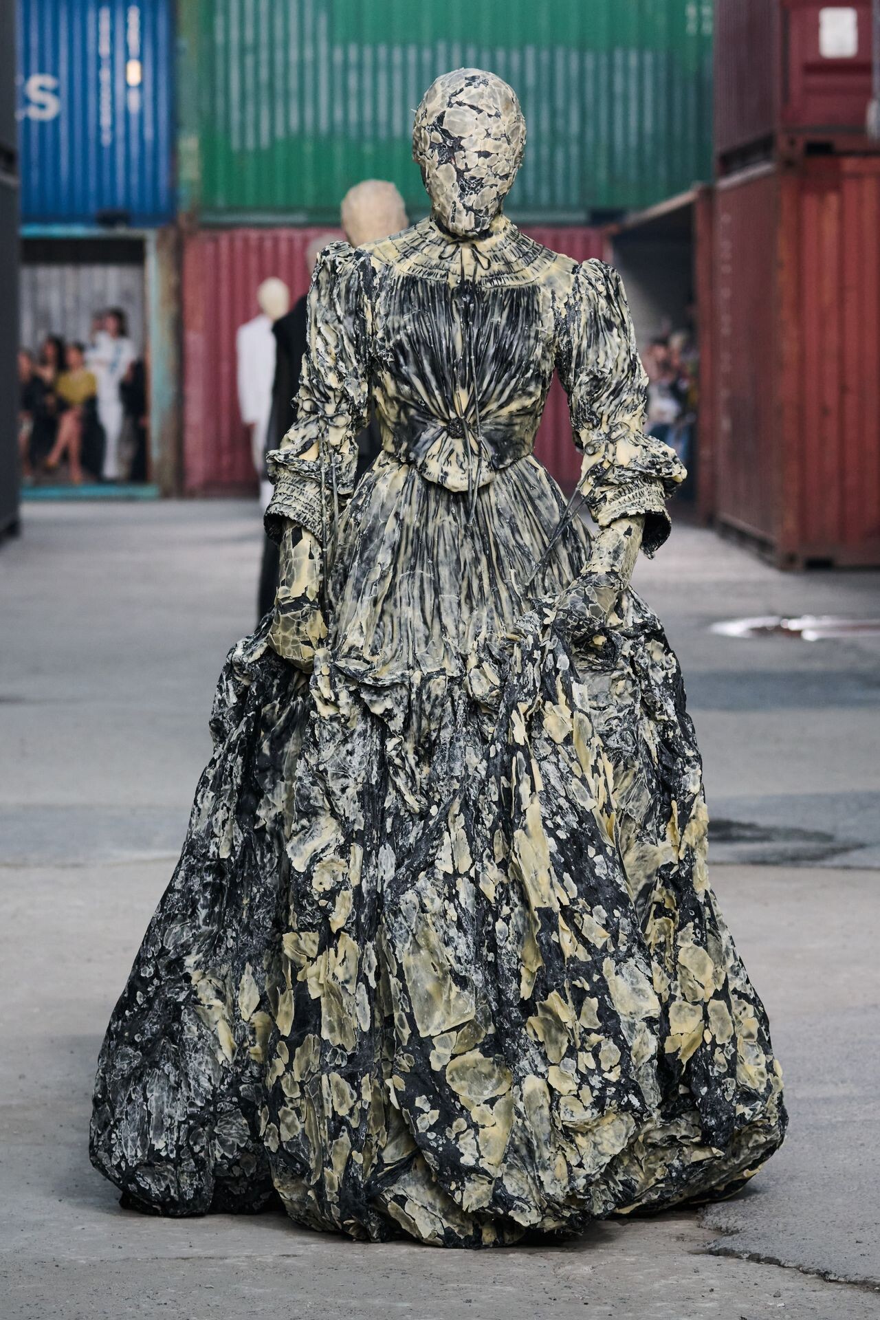 Look del desfile de Maison Margiela otoño-invierno 2026-2027 en Shanghái, con silueta experimental en un entorno industrial