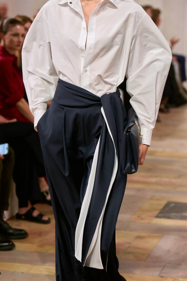 Modelo con camisa blanca de manga larga y falda negra de volúmenes en el desfile de Ralph Lauren Primavera/Verano 2027