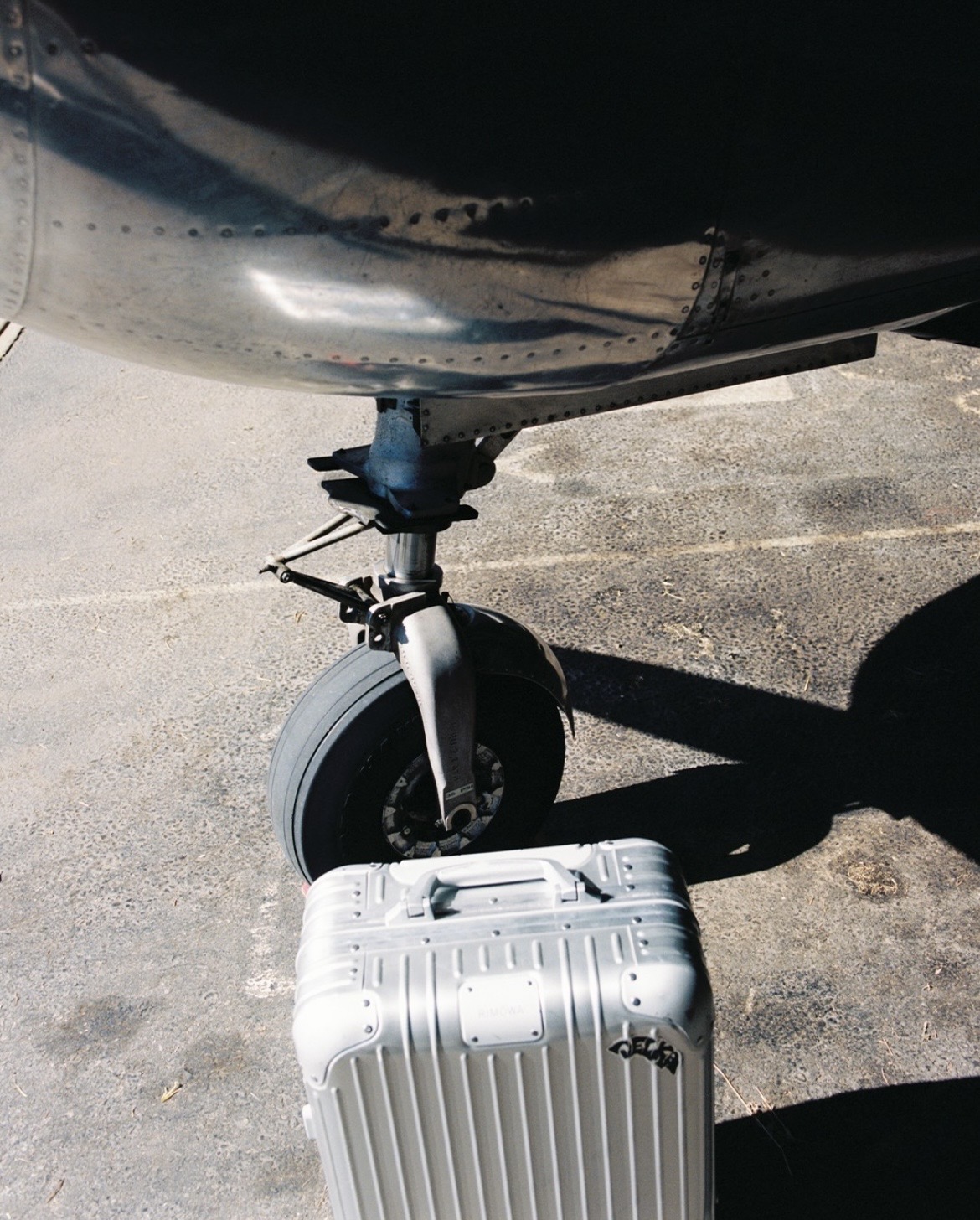 Maleta RIMOWA de aluminio junto a un avión
