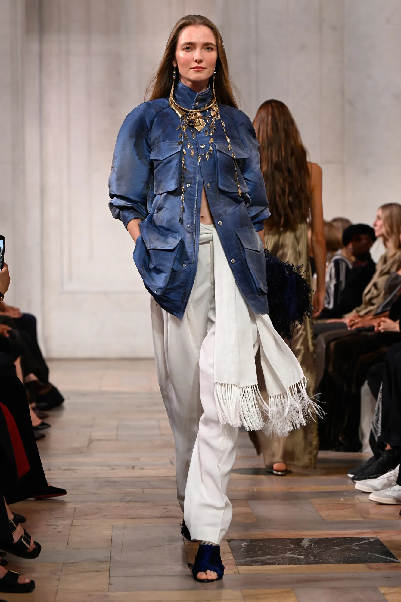 Modelo con chaqueta vaquera de inspiración laboral y detalles de plumas de marabú en el desfile de Ralph Lauren Primavera/Verano 2027