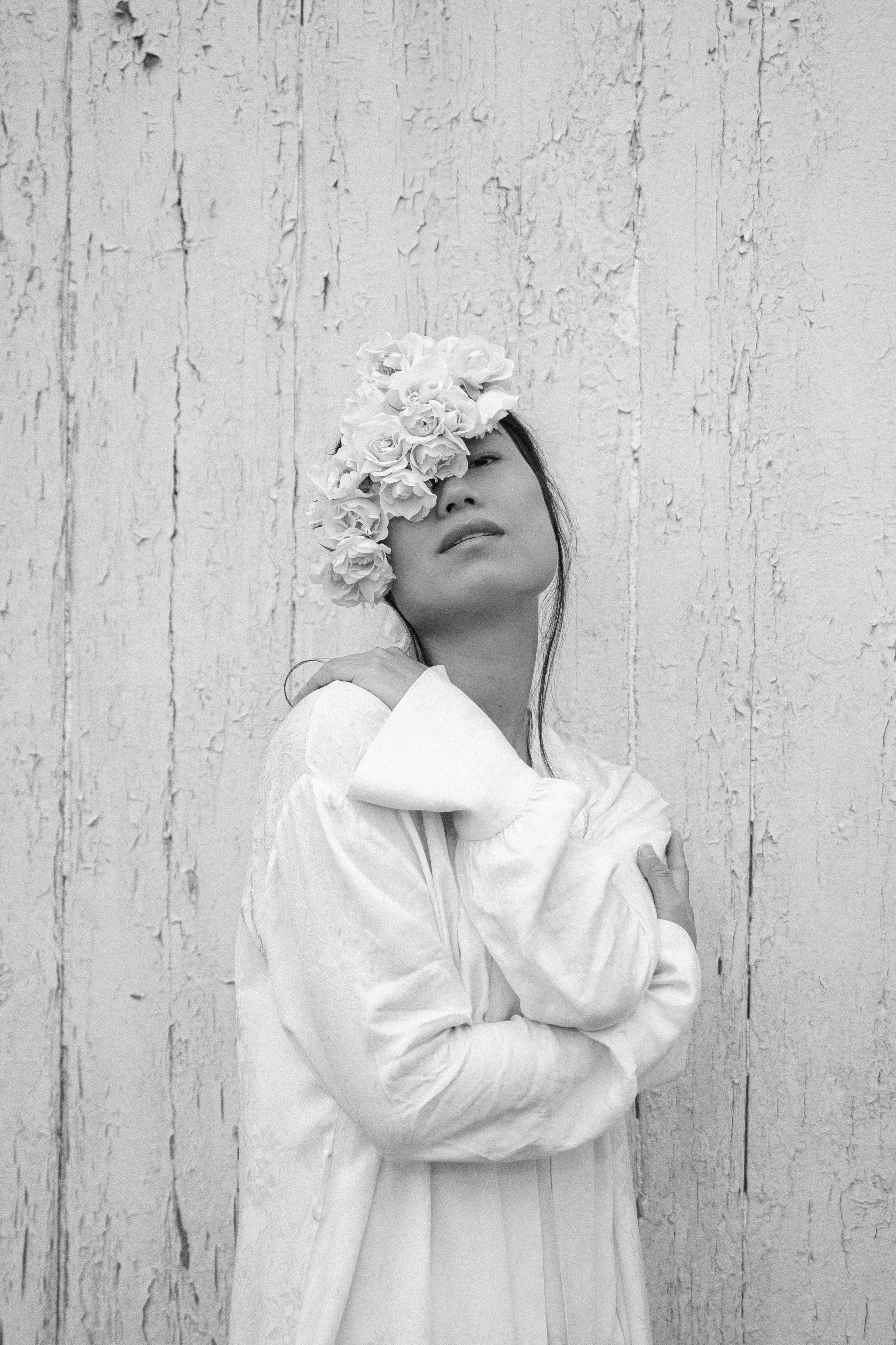 Modelo en blanco y negro con tocado floral artesanal y retrato editorial de primer plano.