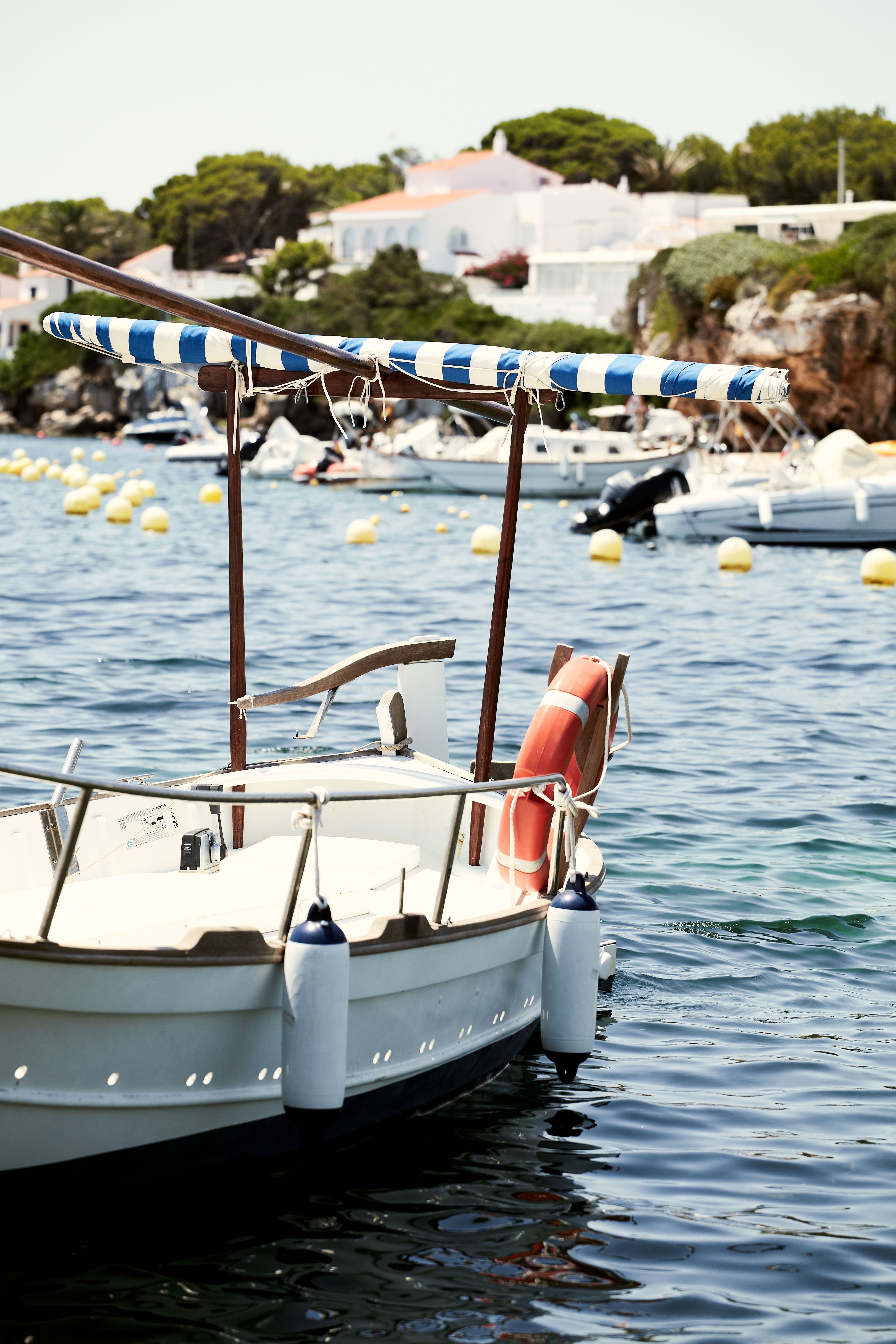 Pequeña embarcación tradicional flotando en aguas cristalinas de Menorca.