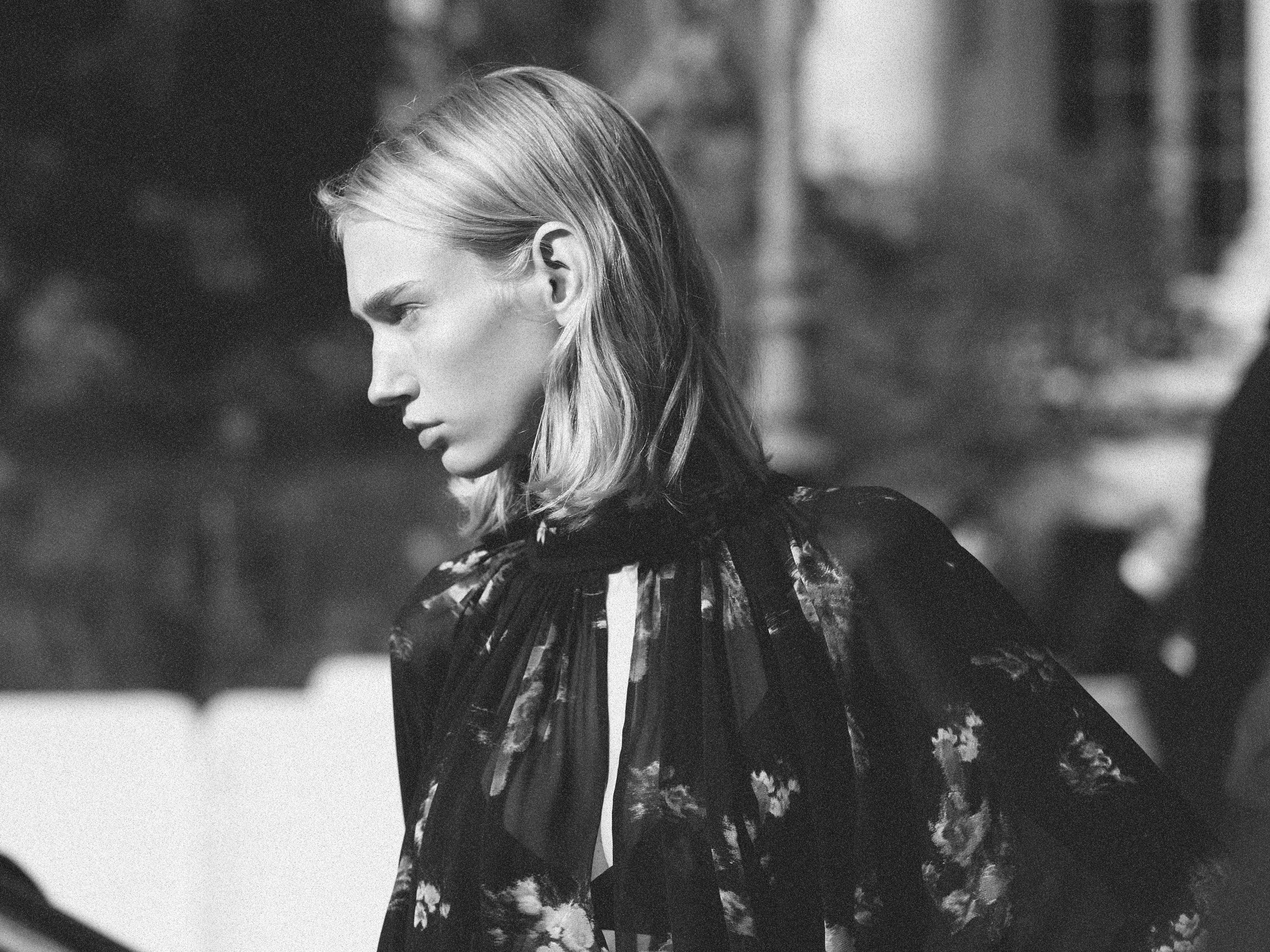 Primer plano en blanco y negro de una modelo femenina en exteriores durante la Semana de la Moda de París.