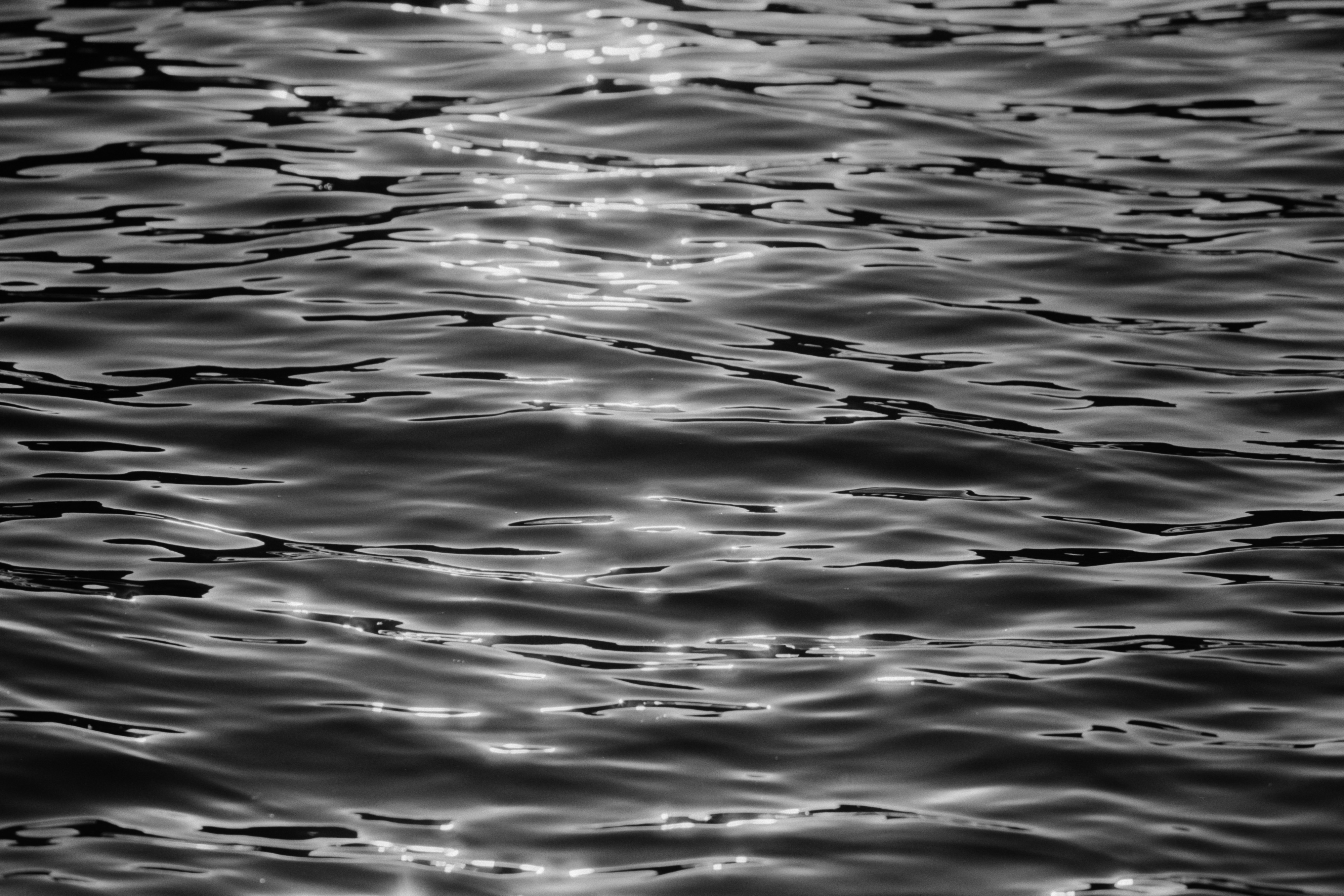 Reflejo de la luz del sol sobre el agua en blanco y negro analogico mar de alicante.